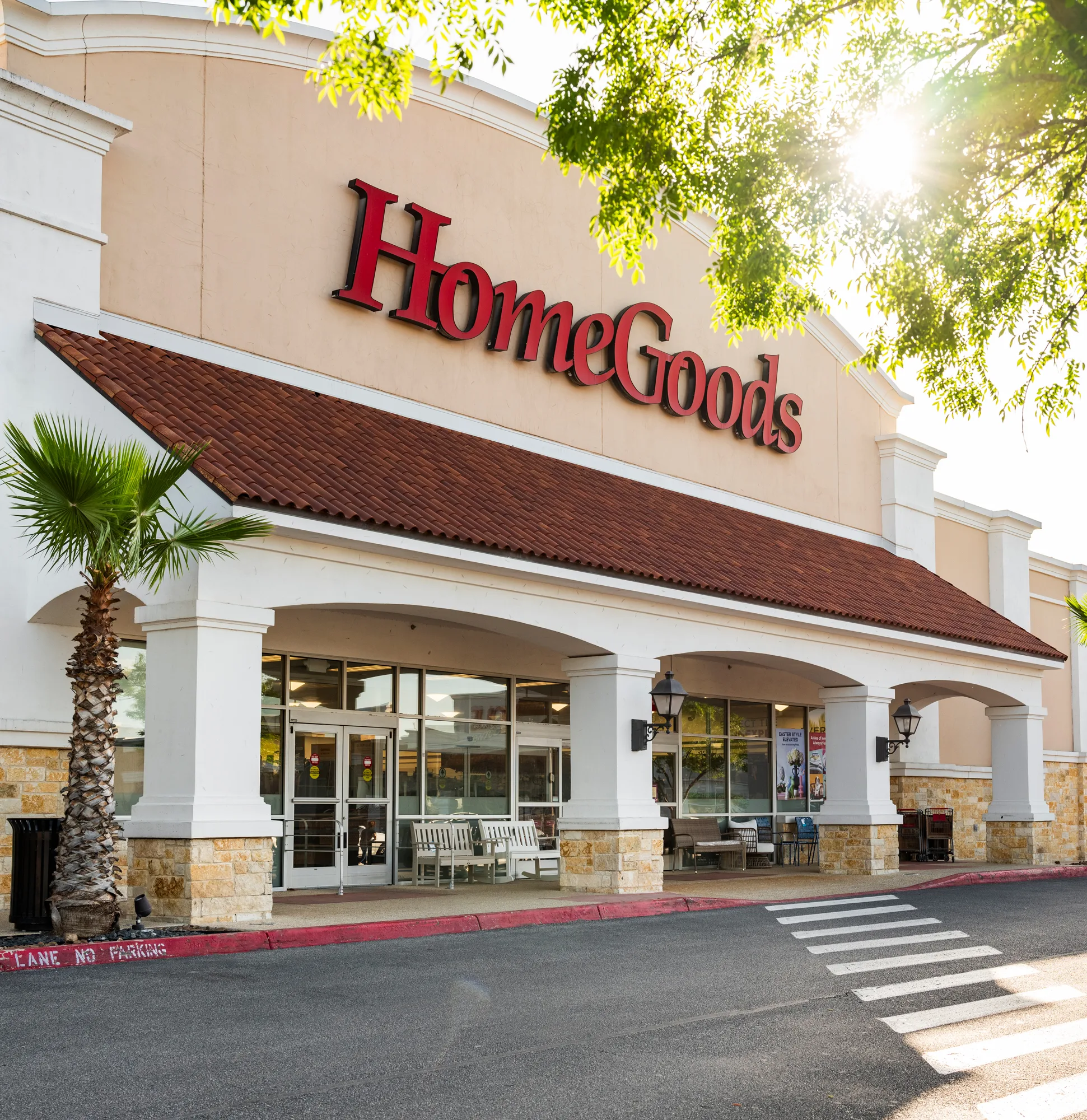 A storefront of HomeGoods with the sun peeking through